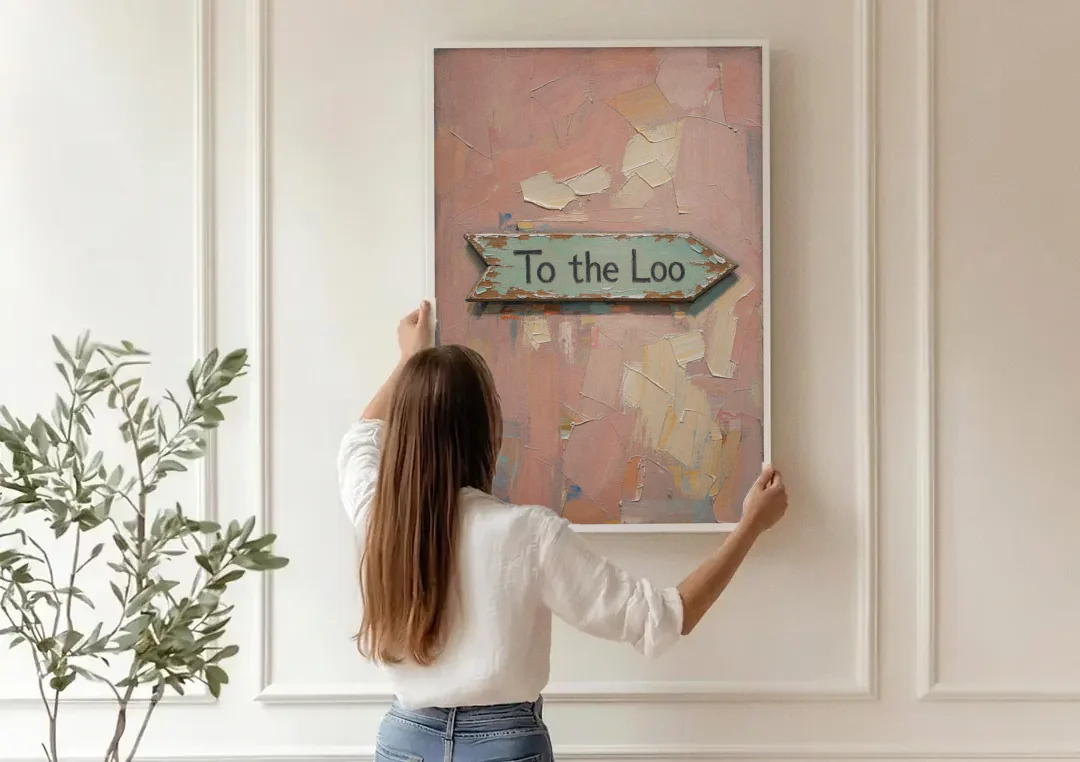 British Bathroom Decor with a Weathered Loo Arrow canvas wall art being hung on a paneled wall