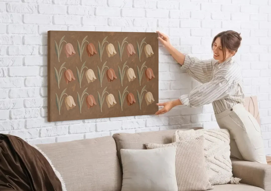 Brown Floral Wall Art with Nodding Tulip Rows canvas wall art being hung on a white brick wall above a sofa