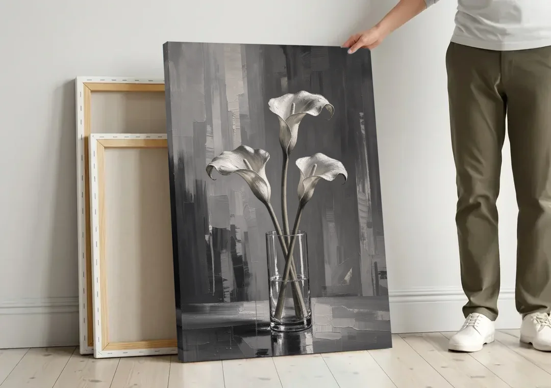 Calla Lily Wall Art with Three Stems in Glass canvas wall art leaning against a wall next to blank canvases