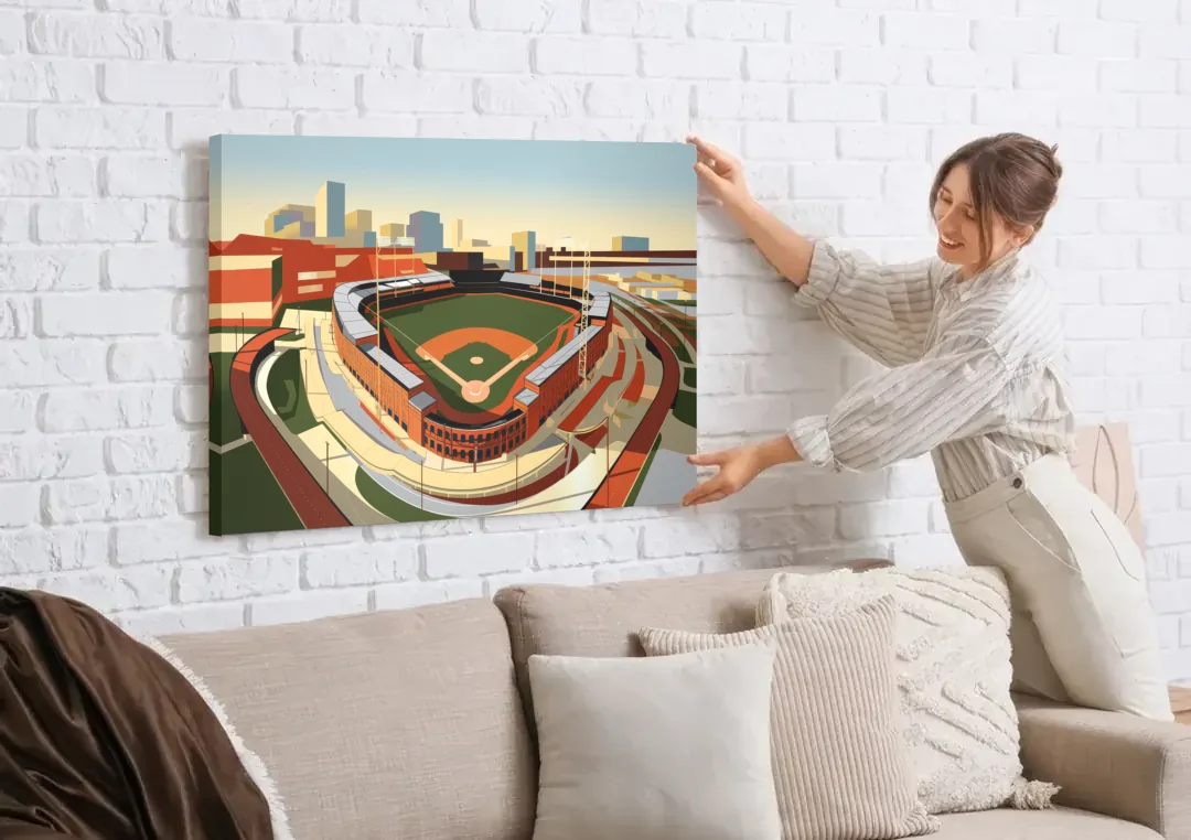 Camden Yards Baseball Stadium canvas wall art being hung on a white brick wall above a sofa