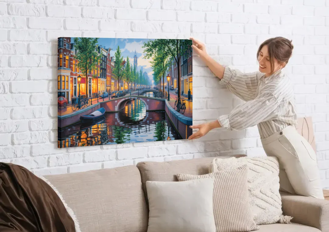 Canals of Amsterdam canvas wall art being hung on a white brick wall above a sofa