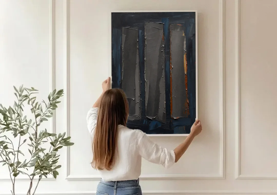 Charcoal Abstract Painting of Three Monoliths canvas wall art being hung on a paneled wall