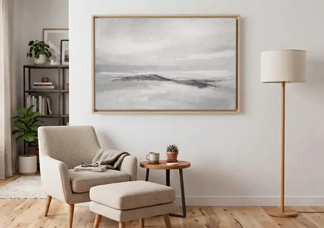 Large Black and White Charcoal Ridge in White Mist canvas wall art above an armchair in a bright living room