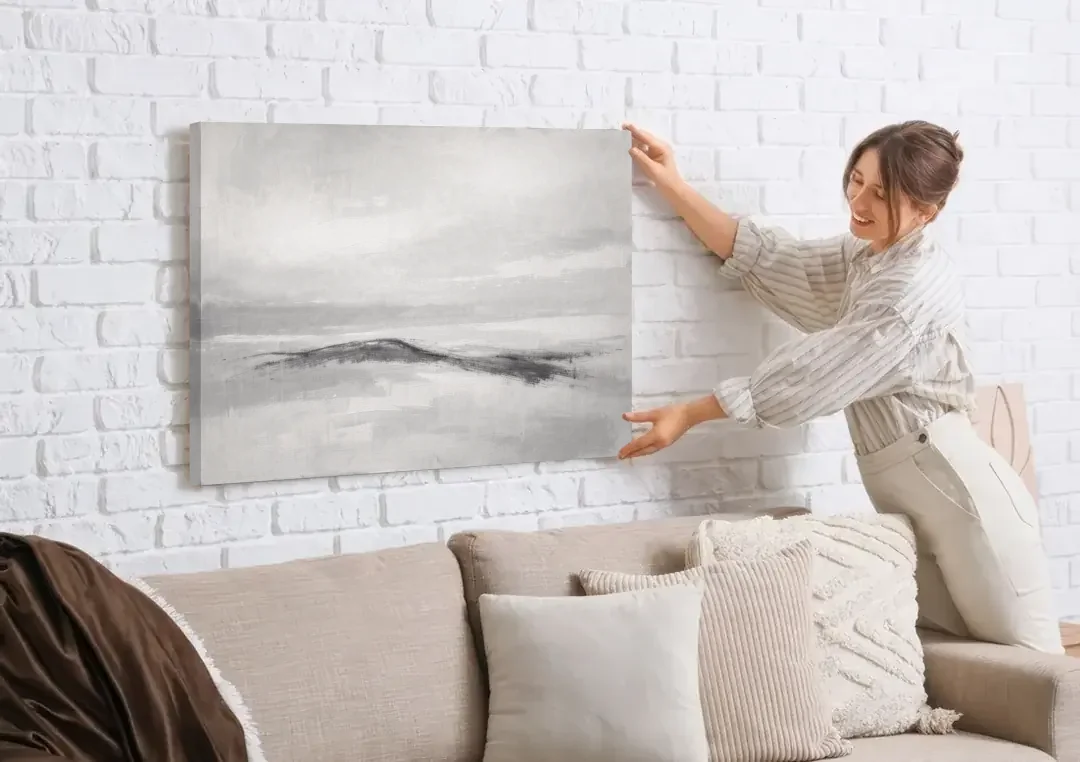 Large Black and White Charcoal Ridge in White Mist canvas wall art being hung on a white brick wall above a sofa