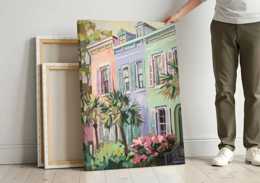 Charleston Rainbow Row canvas wall art leaning against a wall next to blank canvases