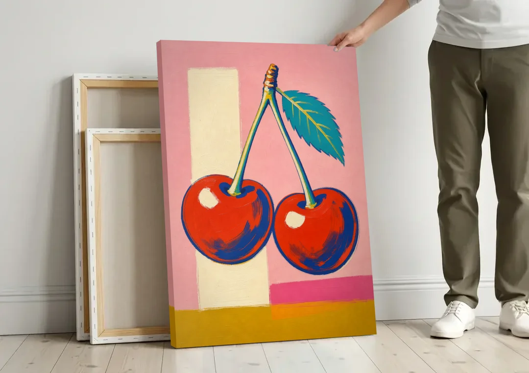 Cherries Painting with a Teal Leaf canvas wall art leaning against a wall next to blank canvases
