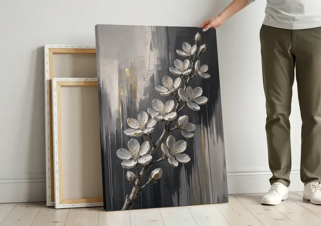 Cherry Blossom Branch Art in Charcoal and Gold canvas wall art leaning against a wall next to blank canvases