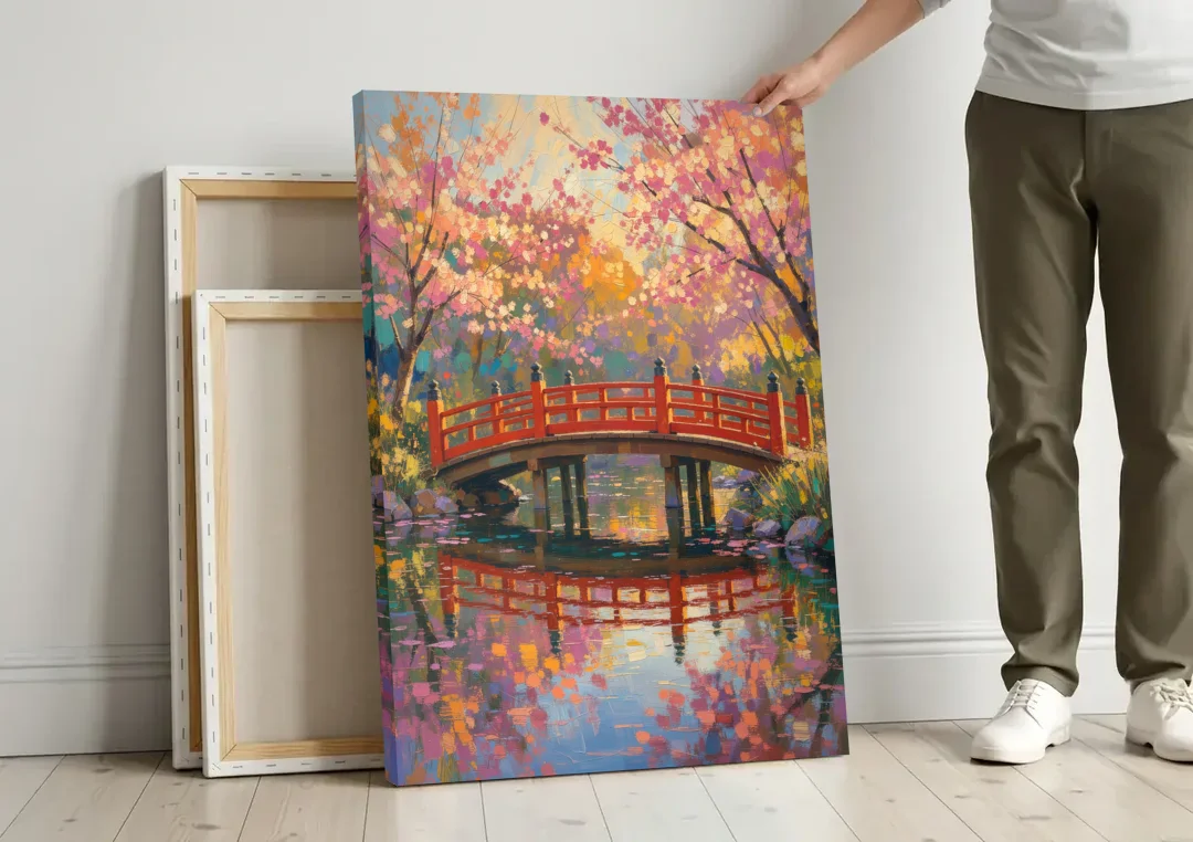 Cherry Blossom Bridge Painting canvas wall art leaning against a wall next to blank canvases