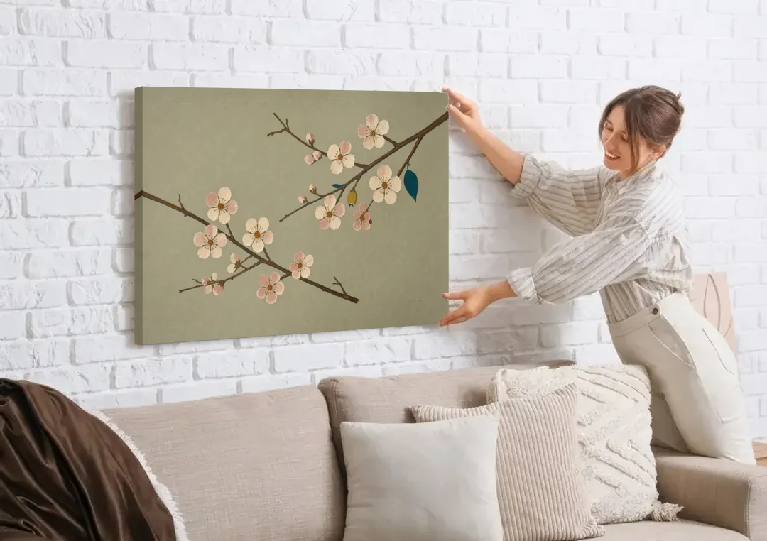 Chinoiserie Wall Art of Crossing Plum Blossom Branches canvas wall art being hung on a white brick wall above a sofa