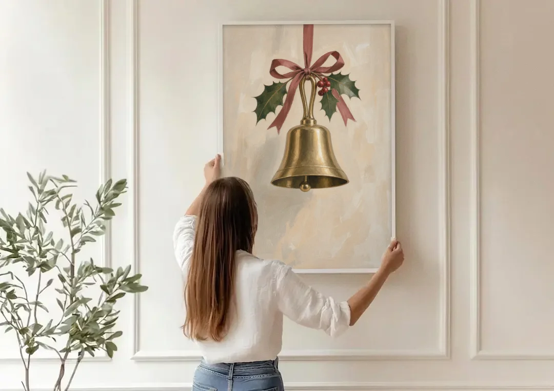 Christmas Bell Painting with Cranberry Ribbon canvas wall art being hung on a paneled wall