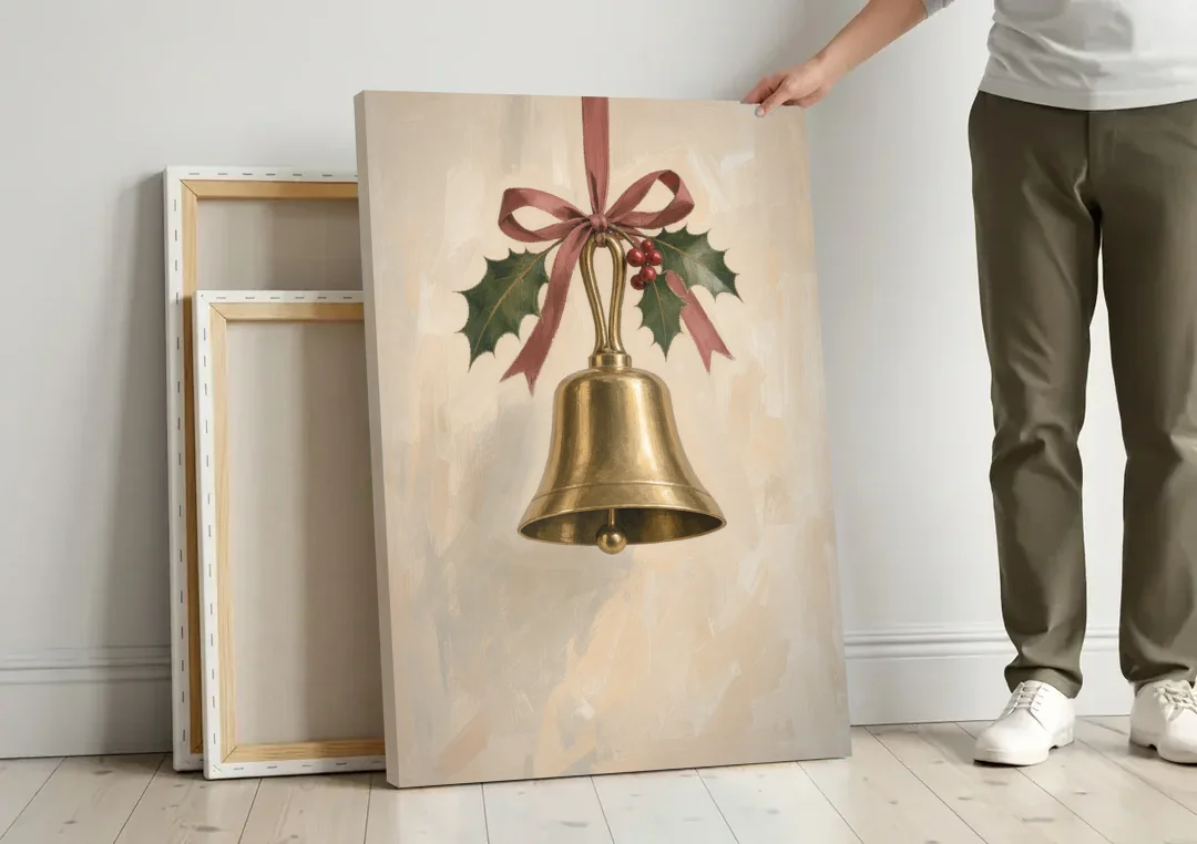 Christmas Bell Painting with Cranberry Ribbon canvas wall art leaning against a wall next to blank canvases