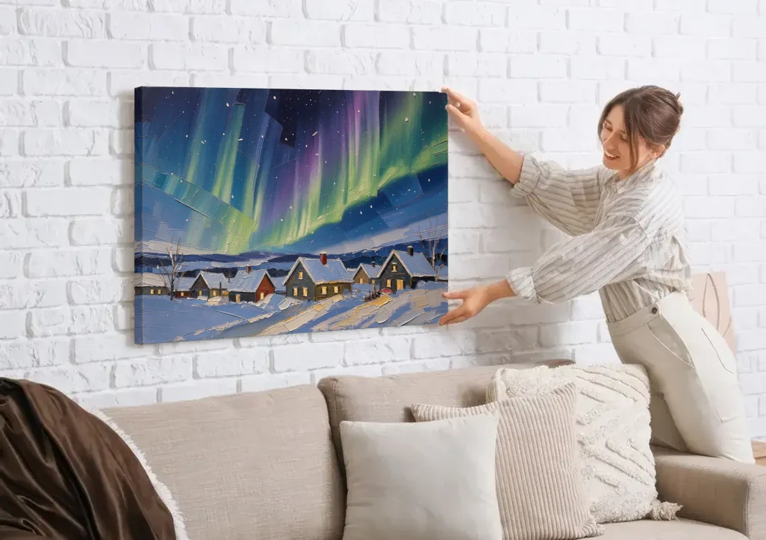 Christmas Landscape Painting Under Northern Lights canvas wall art being hung on a white brick wall above a sofa