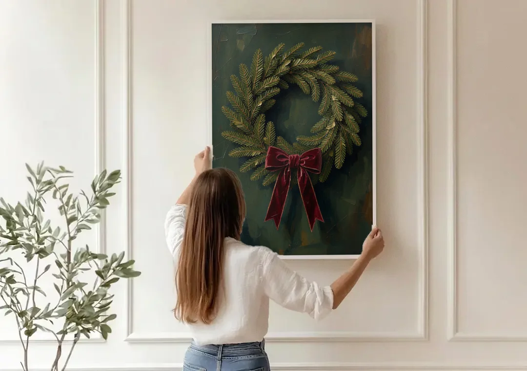 Christmas Wreath Painting with a Velvet Bow canvas wall art being hung on a paneled wall