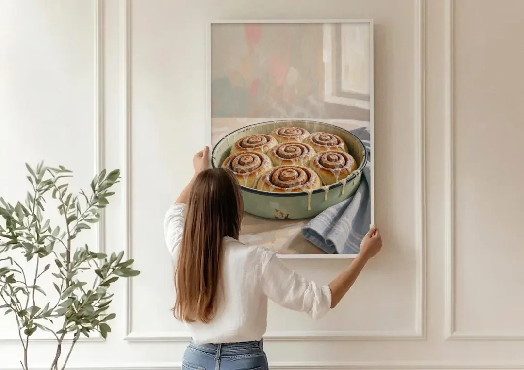 Cinnamon Roll Painting in a Sage Enamel Pan canvas wall art being hung on a paneled wall