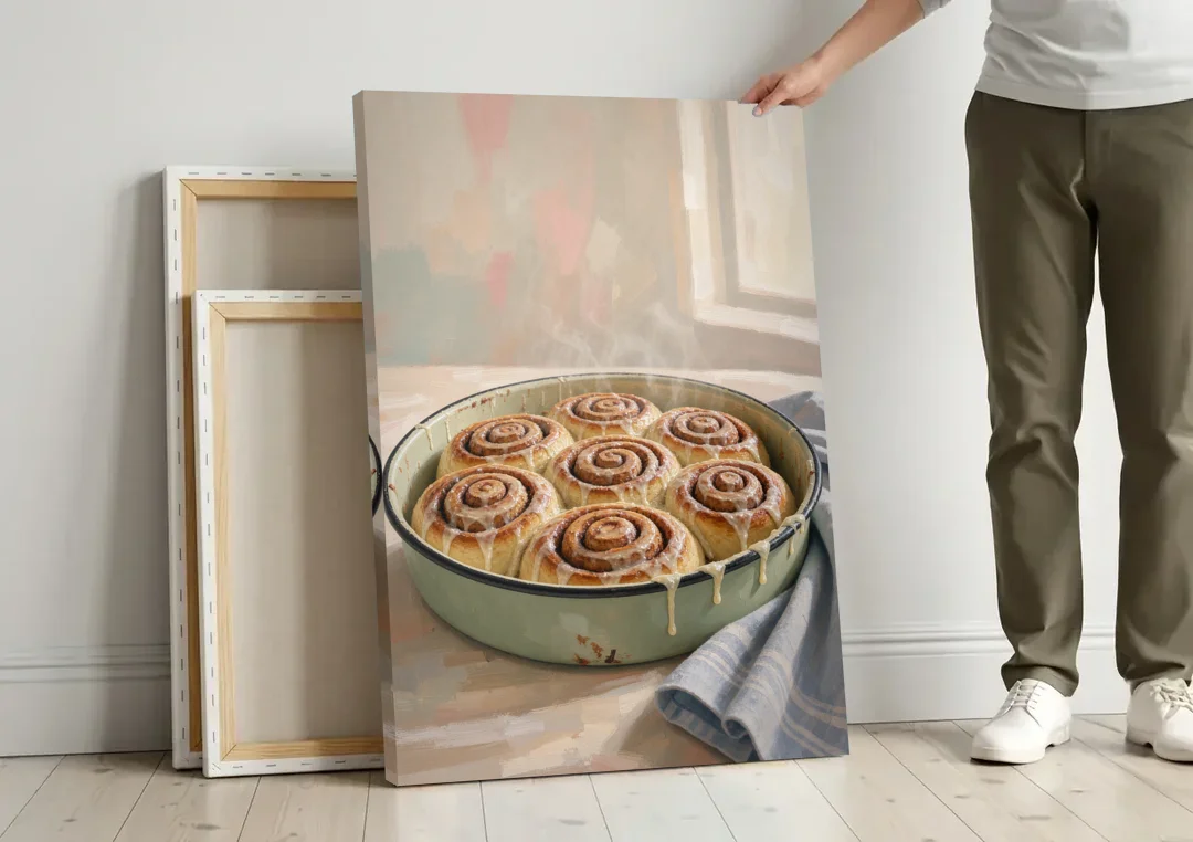 Cinnamon Roll Painting in a Sage Enamel Pan canvas wall art leaning against a wall next to blank canvases