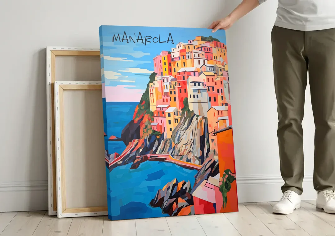 Cinque Terre Art of Manarola canvas wall art leaning against a wall next to blank canvases
