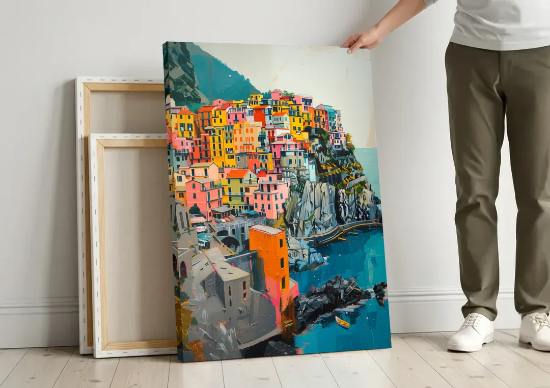 Cinque Terre Painting of a Cliff Village canvas wall art leaning against a wall next to blank canvases