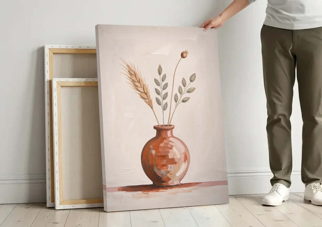 Clay Vase Painting with Three Dried Stems canvas wall art leaning against a wall next to blank canvases