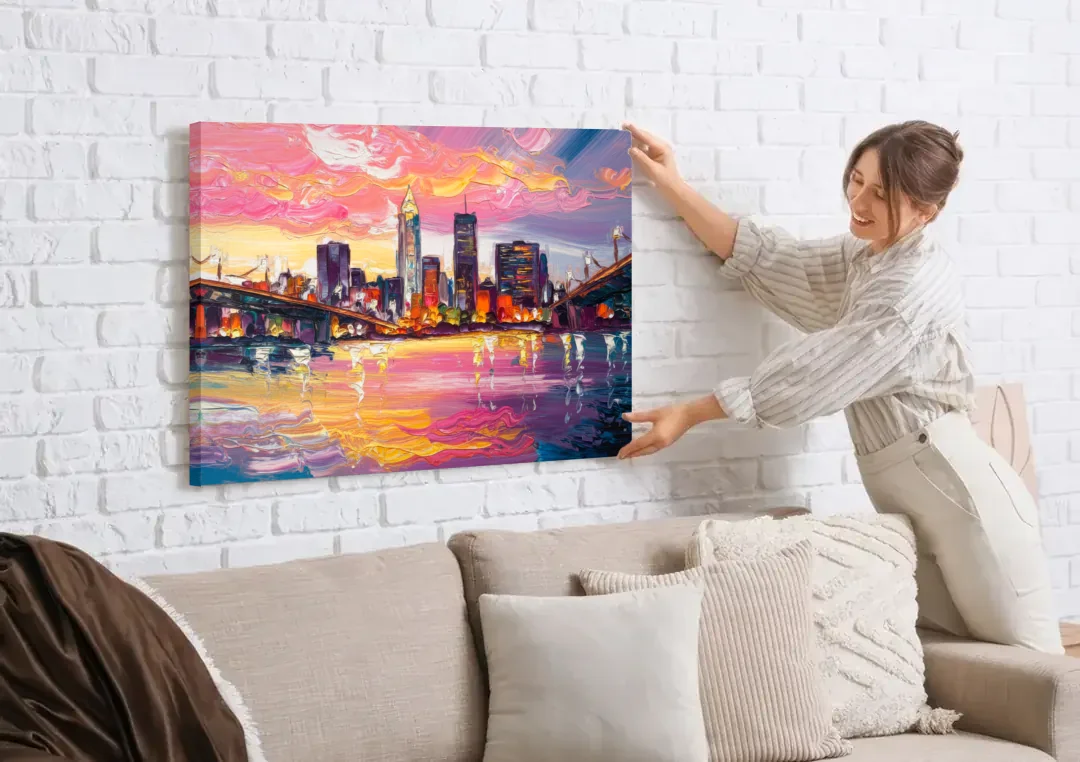 Cleveland Skyline At Sunset canvas wall art being hung on a white brick wall above a sofa