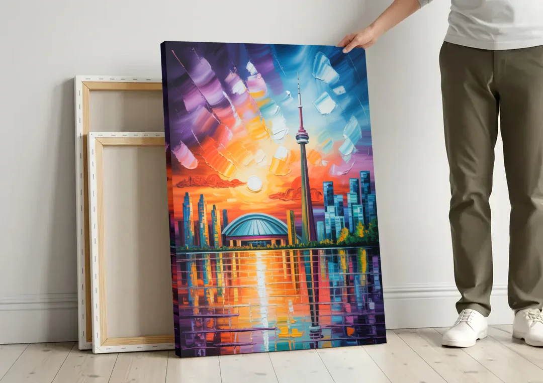 CN Tower Sunset Watercolor canvas wall art leaning against a wall next to blank canvases