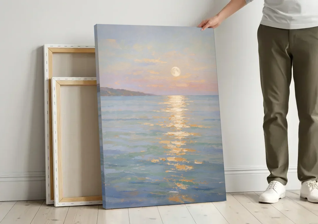 Coastal Art Prints Moon Path Over Calm Sea canvas wall art leaning against a wall next to blank canvases