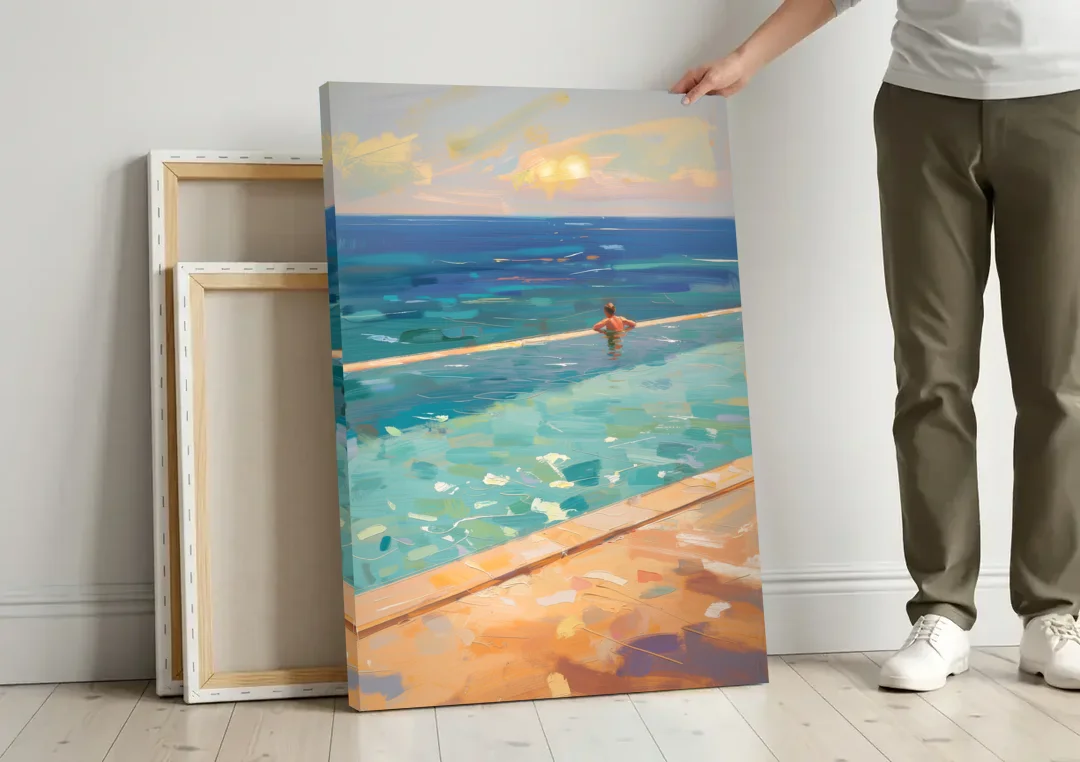 Coastal Modern Wall Art of an Infinity Pool Swimmer canvas wall art leaning against a wall next to blank canvases