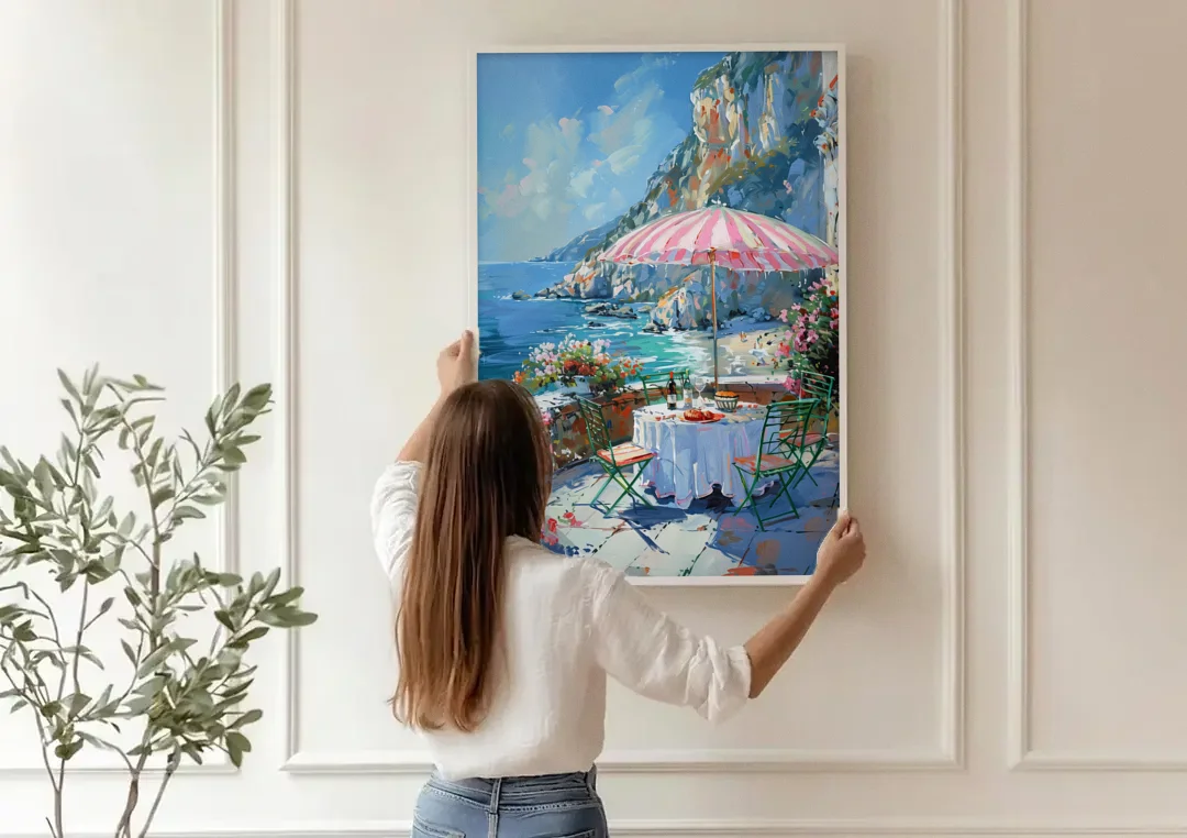Coastal Painting with a Pink Striped Umbrella canvas wall art being hung on a paneled wall