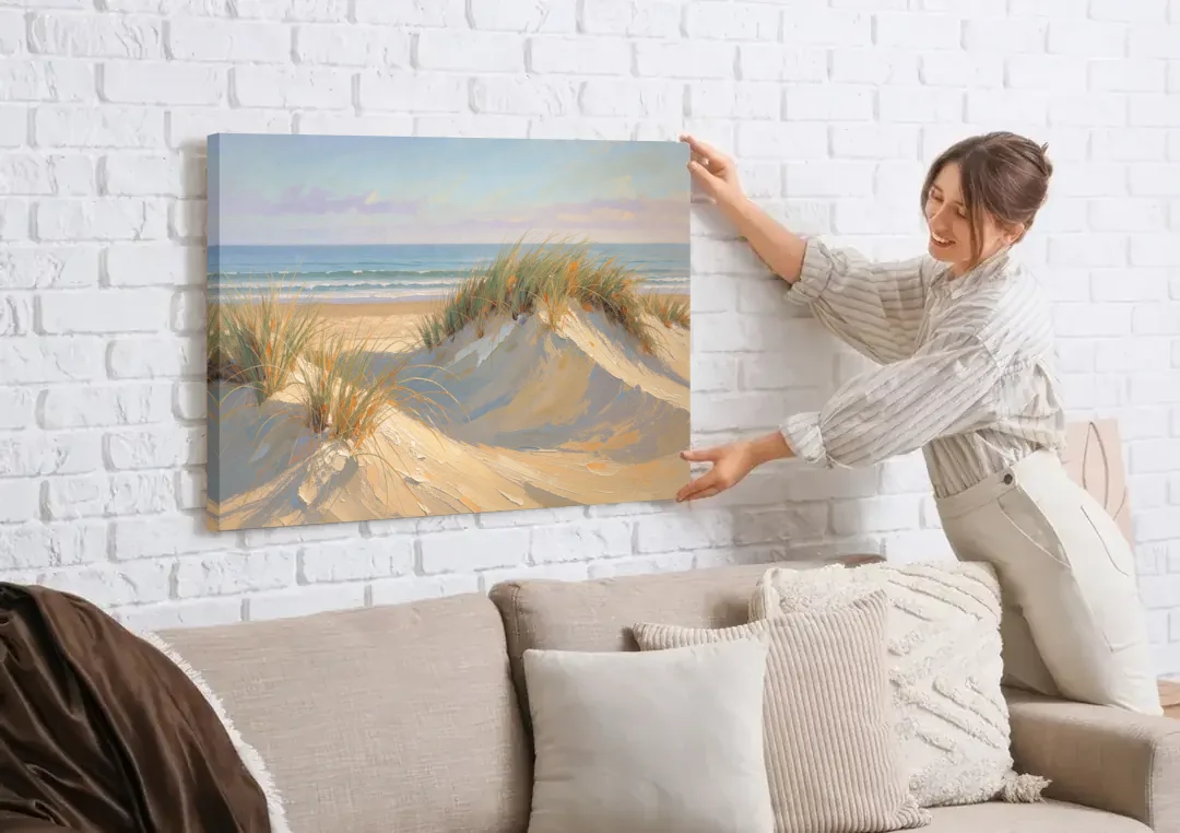 Coastal Paintings of Sea Grass Dunes canvas wall art being hung on a white brick wall above a sofa