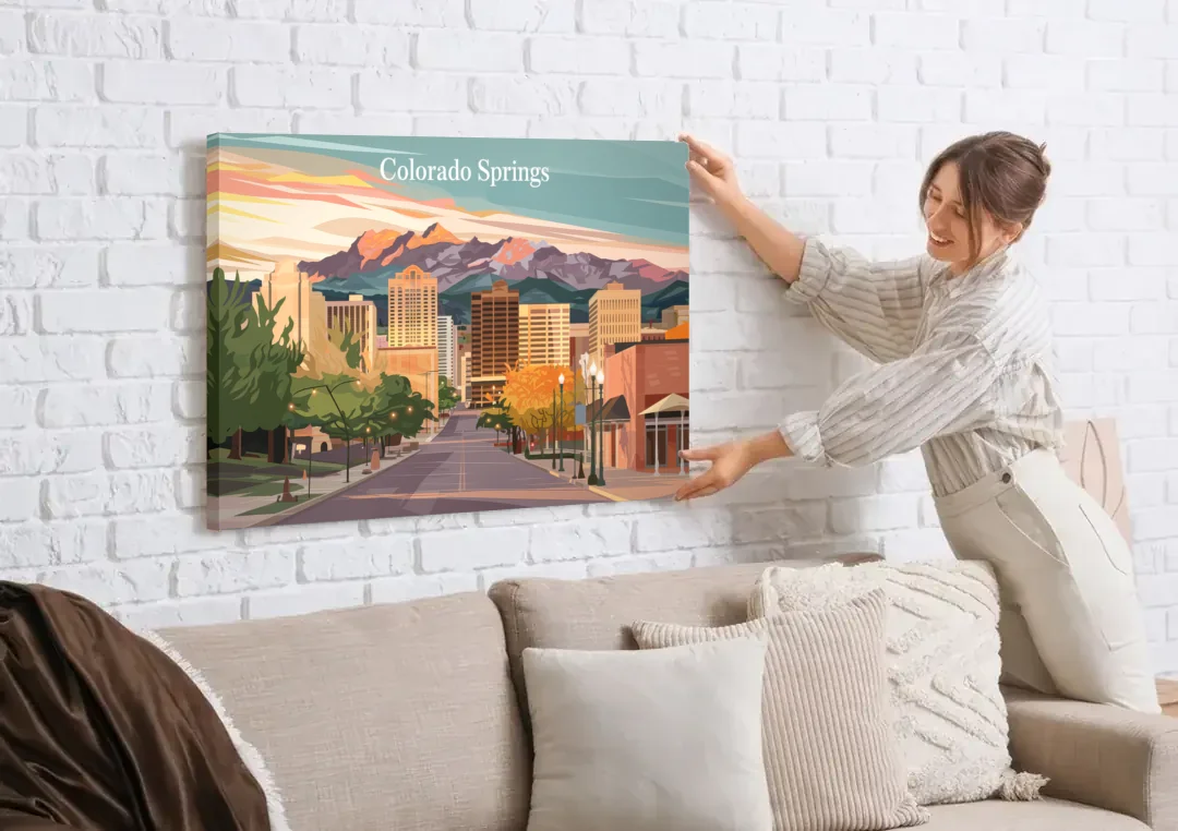 Colorado Springs Downtown Charm canvas wall art being hung on a white brick wall above a sofa