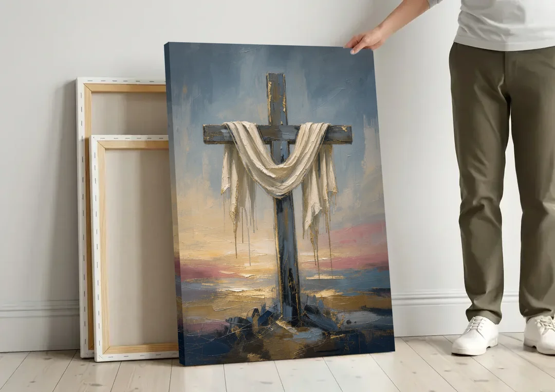 Contemporary Christian Art of the Draped Cross at Dawn canvas wall art leaning against a wall next to blank canvases