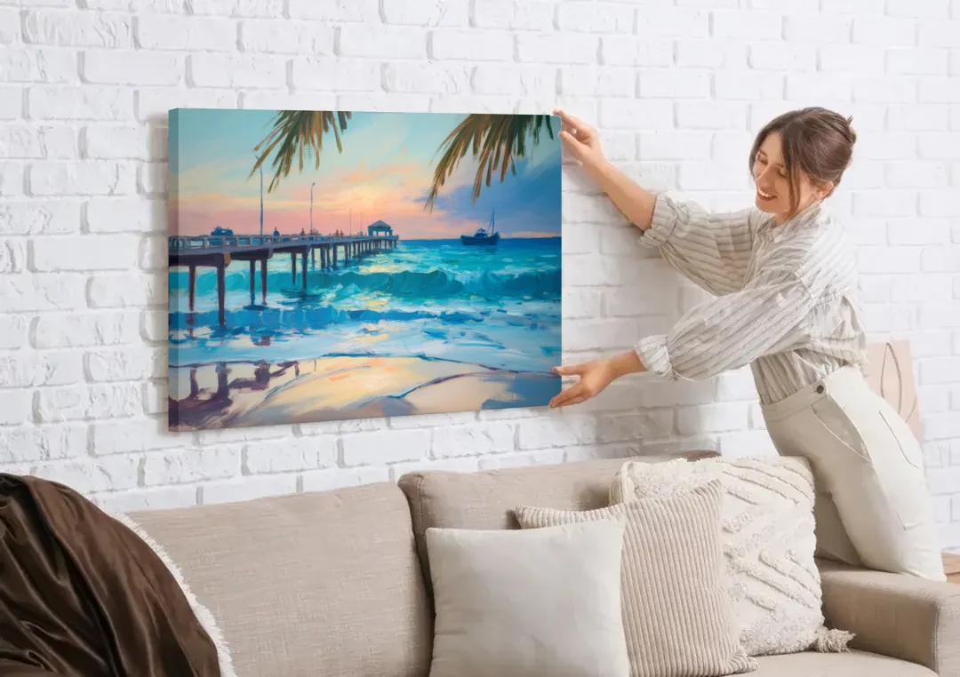 Cozumel Pier Sunrise canvas wall art being hung on a white brick wall above a sofa