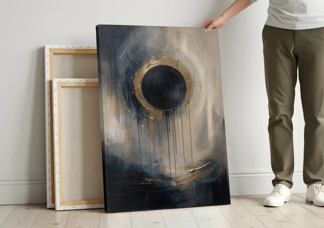 Dark Moody Abstract Bronze Eclipse canvas wall art leaning against a wall next to blank canvases