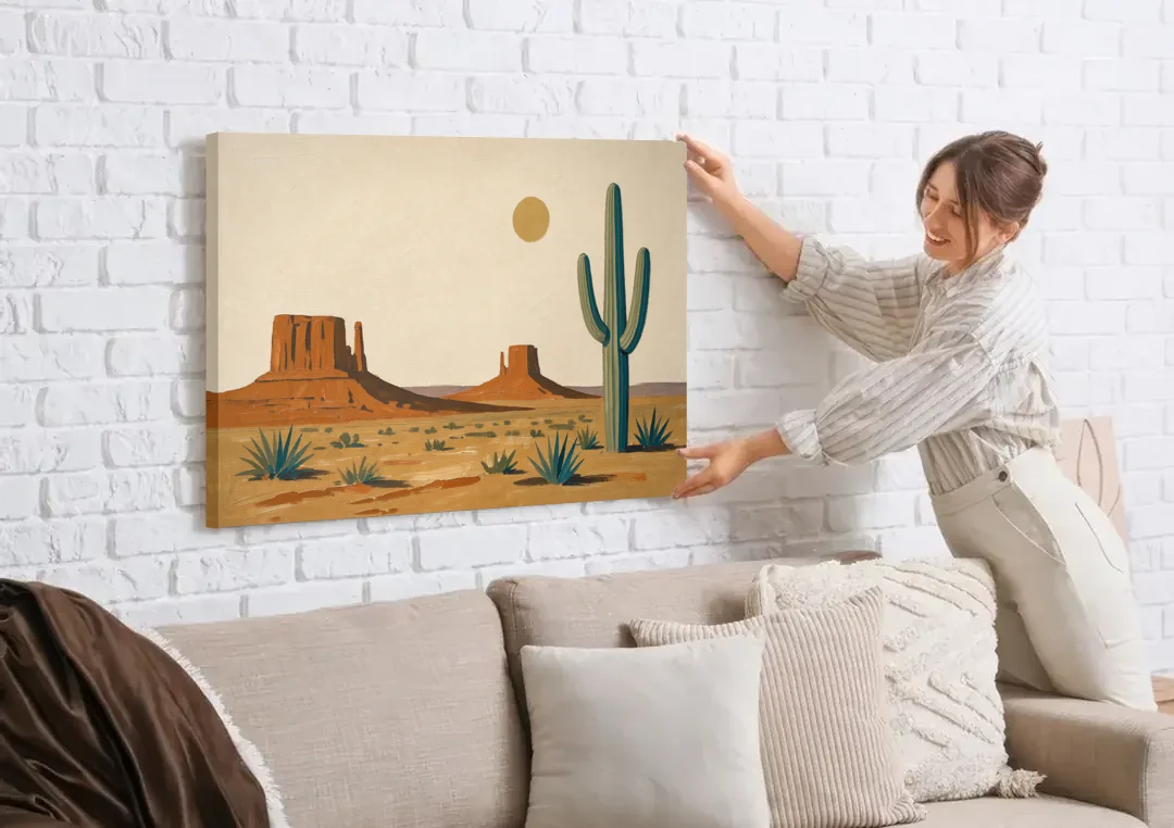 Desert Wall Art with Two Mesas and a Saguaro canvas wall art being hung on a white brick wall above a sofa