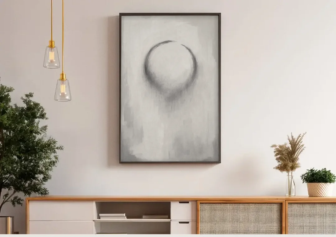 Minimalist Black and White Dissolving Charcoal Circle canvas wall art above a wooden sideboard under pendant lights