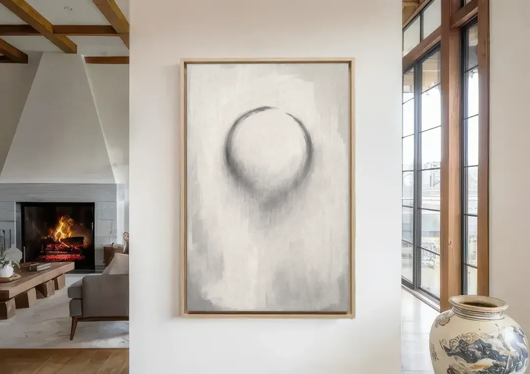 Minimalist Black and White Dissolving Charcoal Circle canvas wall art in a living room with a fireplace