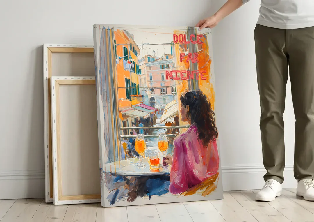 Dolce Far Niente Painting with a Spritz canvas wall art leaning against a wall next to blank canvases