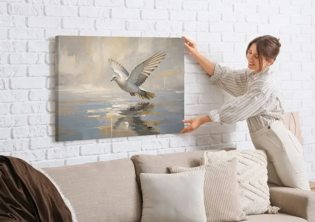 Dove Wall Art with Wings Over Still Water canvas wall art being hung on a white brick wall above a sofa