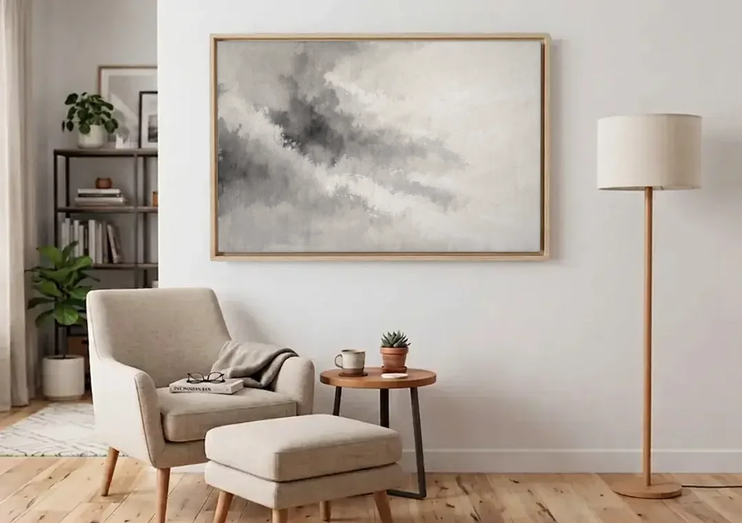 Monochrome Drifting Weather in Soft Gray Wash canvas wall art above an armchair in a bright living room