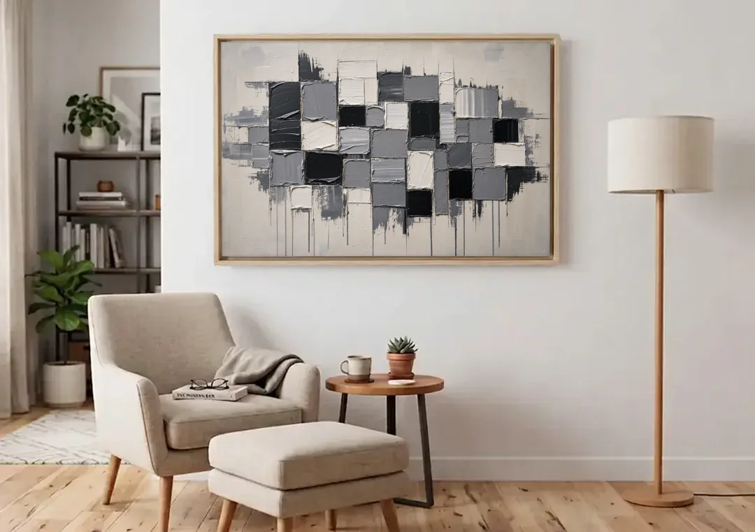 Dripping Grid of Black and Grey Squares canvas wall art above an armchair in a bright living room