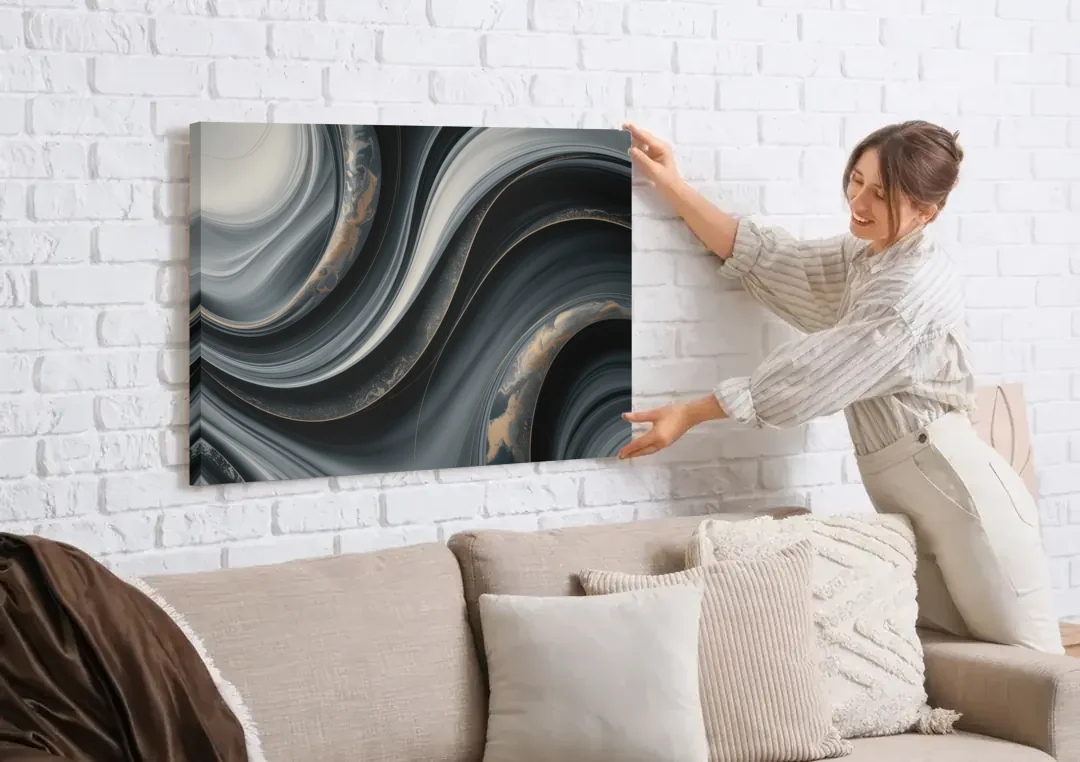 Elegant Ripples Black and Grey Abstract canvas wall art being hung on a white brick wall above a sofa