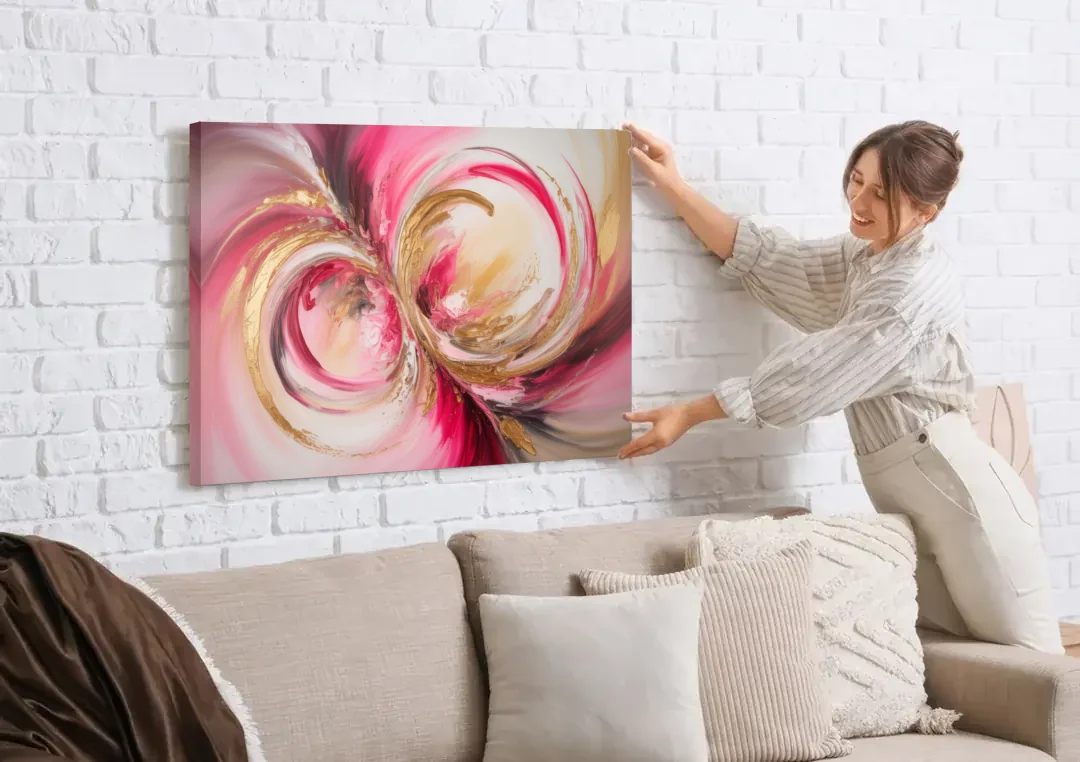 Elegant Swirl Pink and Gold Abstract canvas wall art being hung on a white brick wall above a sofa