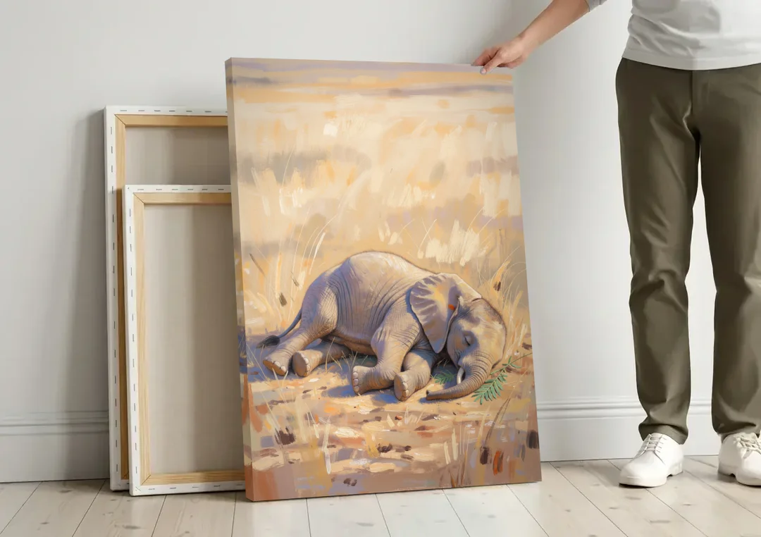 Elephant Calf Asleep on Its Side canvas wall art leaning against a wall next to blank canvases