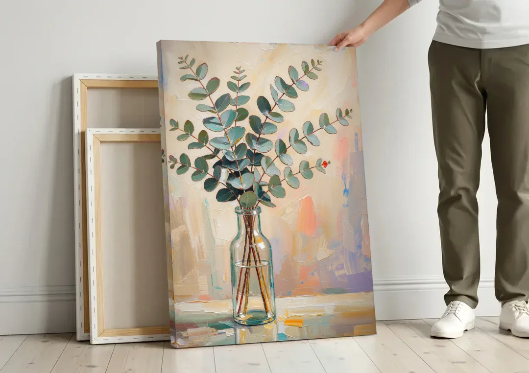 Eucalyptus Canvas Print in a Glass Bottle canvas wall art leaning against a wall next to blank canvases