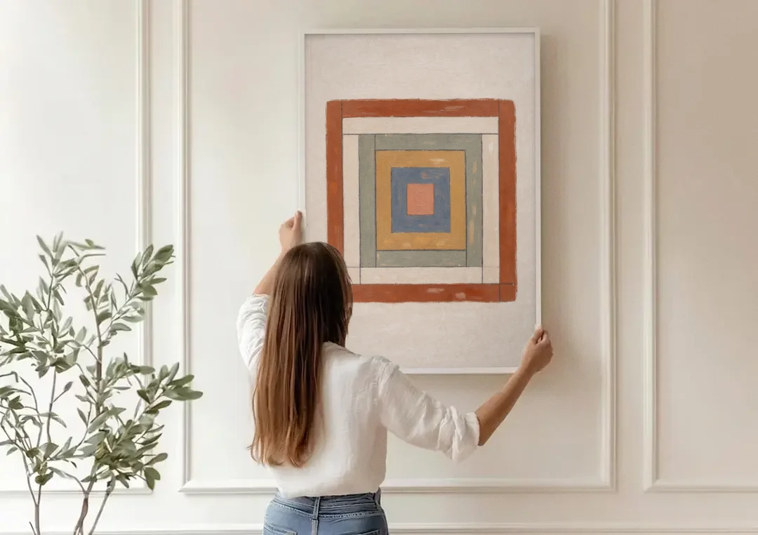 Framed Boho Wall Art with Nested Quilt Squares canvas wall art being hung on a paneled wall