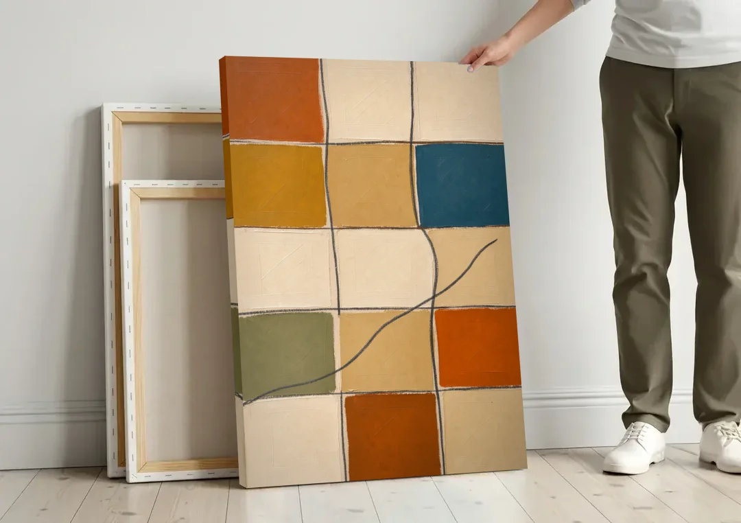 Framed Geometric Wall Art with a Wandering Line canvas wall art leaning against a wall next to blank canvases