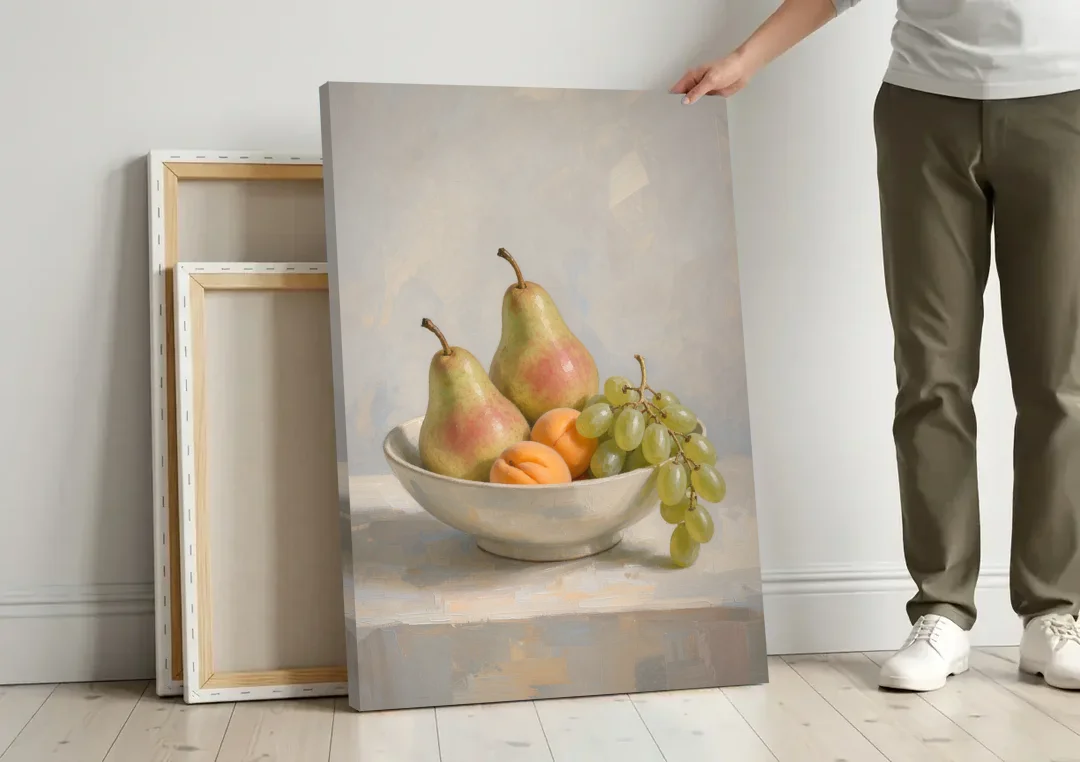 Fruit Bowl Still Life Painting With Pears and Grapes canvas wall art leaning against a wall next to blank canvases