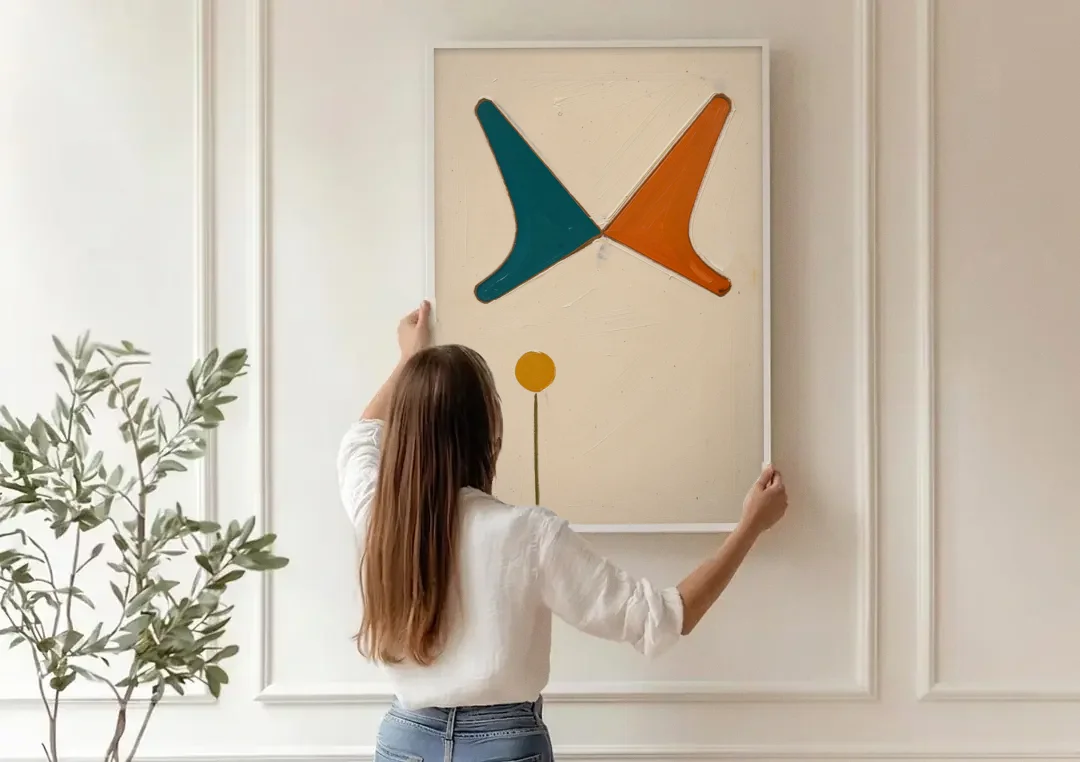 Geometric Abstract Painting of Crossed Teal and Orange Boomerangs canvas wall art being hung on a paneled wall