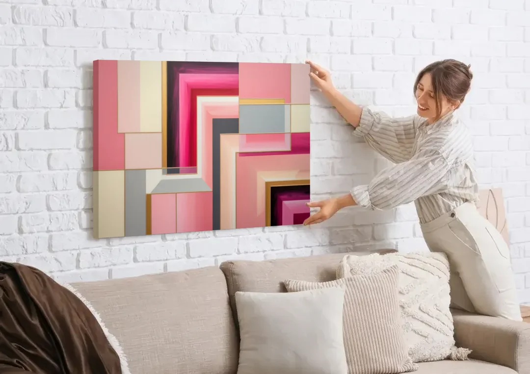 Geometric Elegance in Pink Abstract canvas wall art being hung on a white brick wall above a sofa