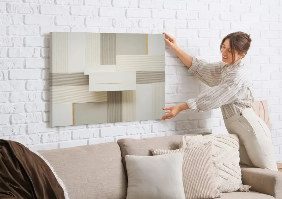 Geometric Harmony in White Abstract canvas wall art being hung on a white brick wall above a sofa
