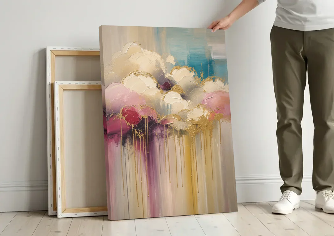 Gilded Clouds With Raspberry Rain Drips canvas wall art leaning against a wall next to blank canvases